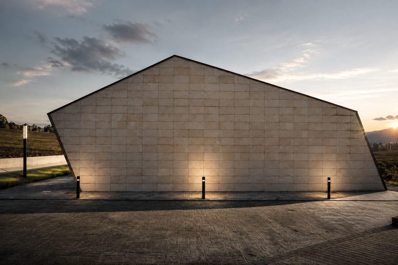 Edificio dotacional de piedra al atardecer, proyecto de Pedreira Arquitectura